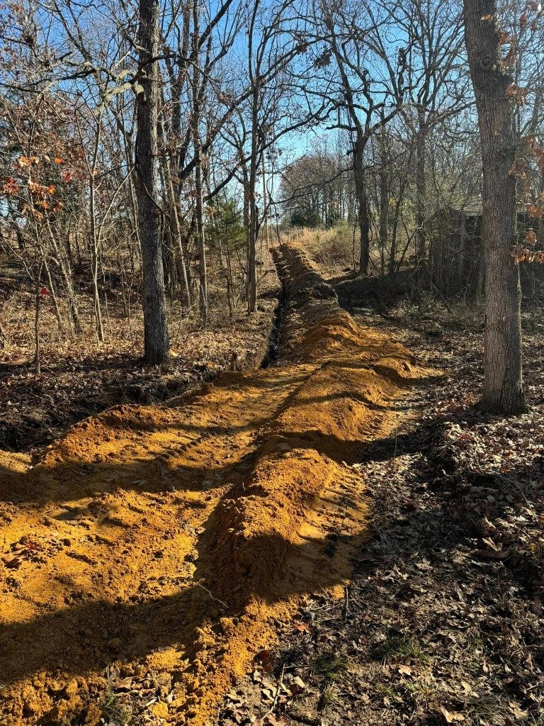 Open utility trench running through the woods in Southwest Missouri